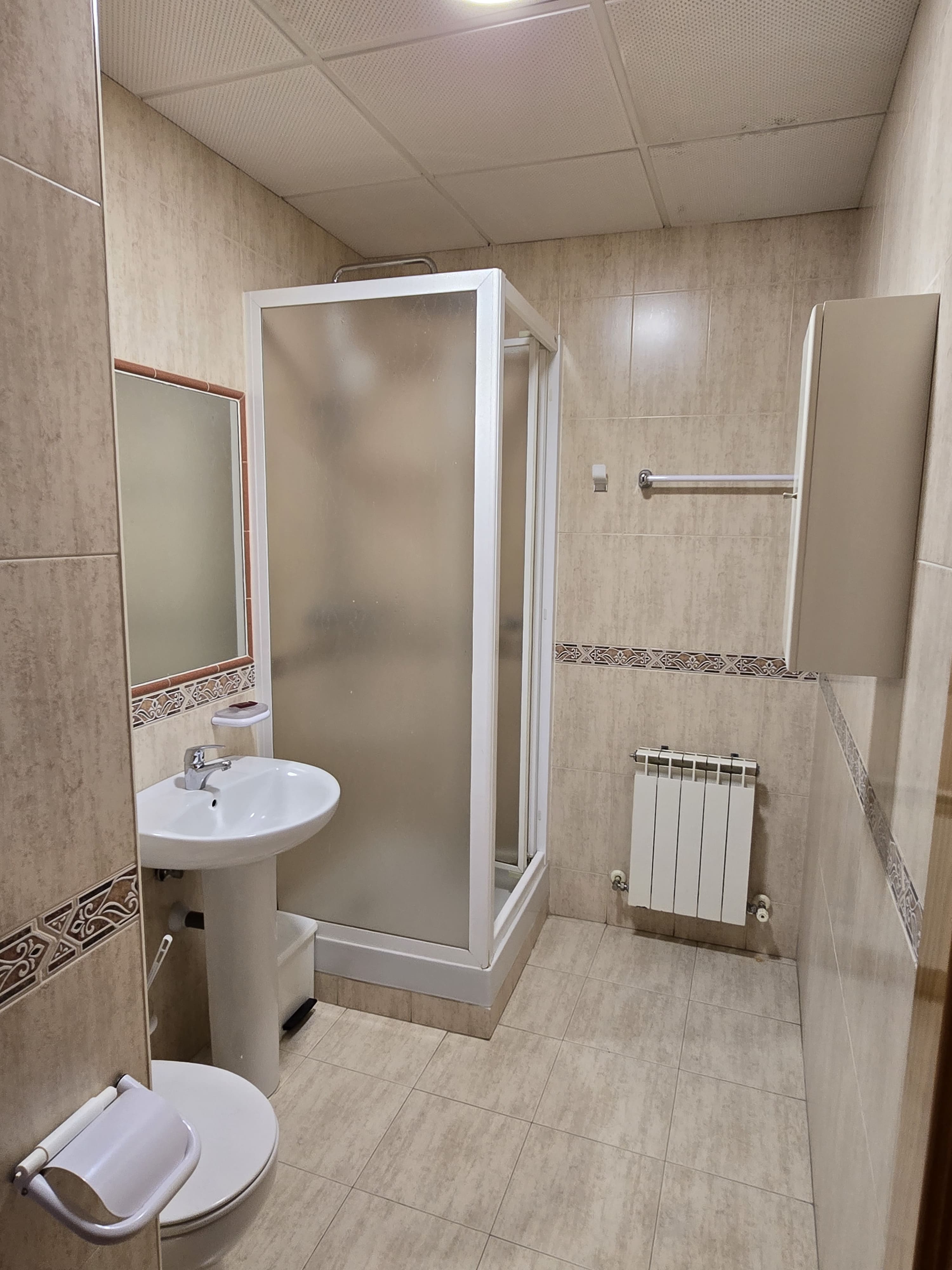 Baño con cabina ducha, lavabo y radiador en doble estándar
